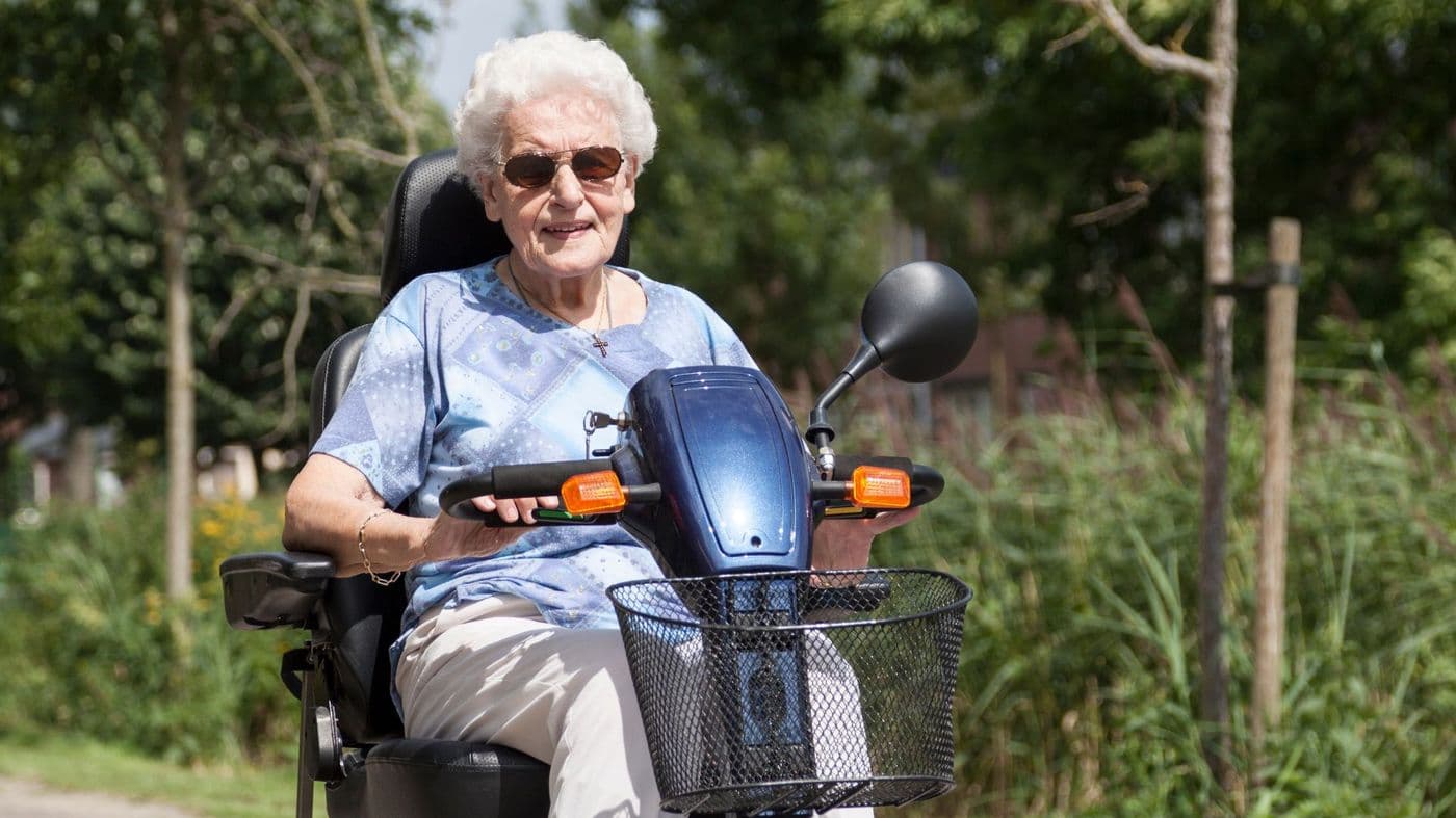 A customer smiling while out on her mobility scooter